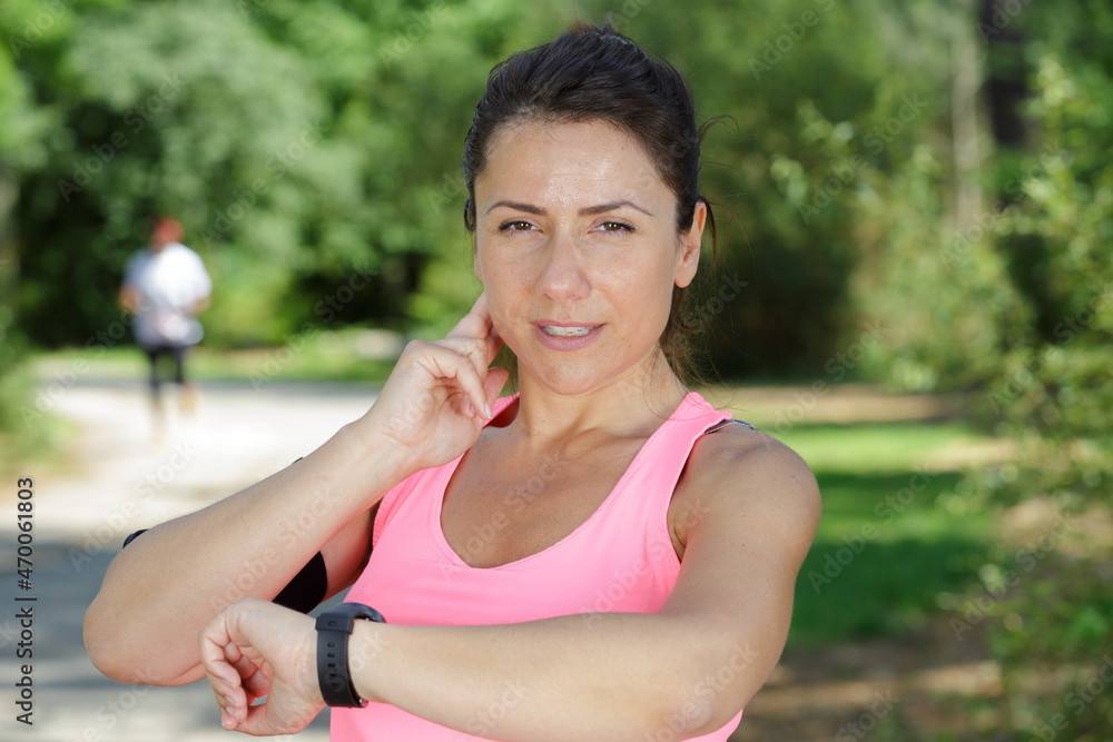 female runner looking at her sport watch female runner looking at her sport watch