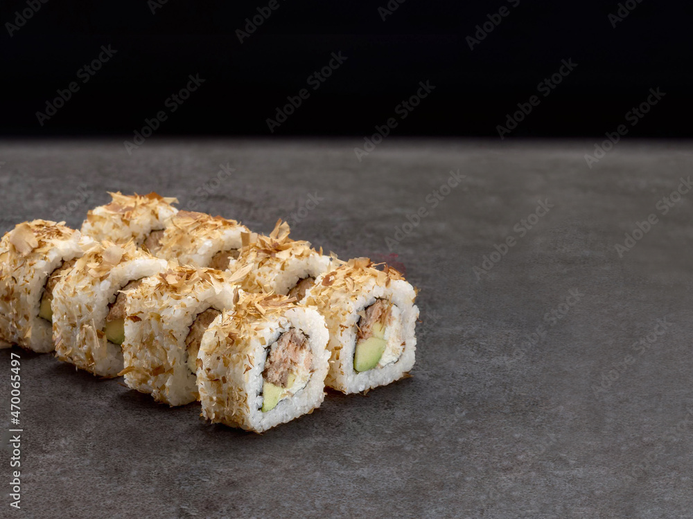 Japanese sushi roll with roasted salmon and avocado inside roll. Asian dish pieces with tuna chips Bonito on dark concrete background. Copy space image. Single object
Japanese sushi roll with roasted salmon and avocado inside roll. Asian dish pieces with tuna chips Bonito on dark concrete background. Copy space image. Single object