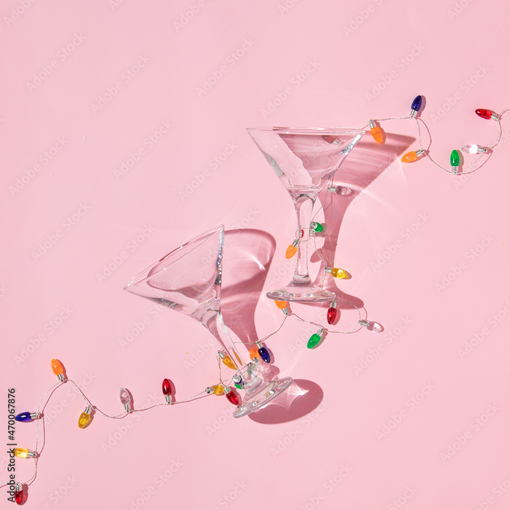 Christmas party creative layout with martini cocktail glasses and christmas  lights decoration on pastel pink background. Retro fashion aesthetic party  concept. New Year celebration idea. foto de Stock | Adobe Stock