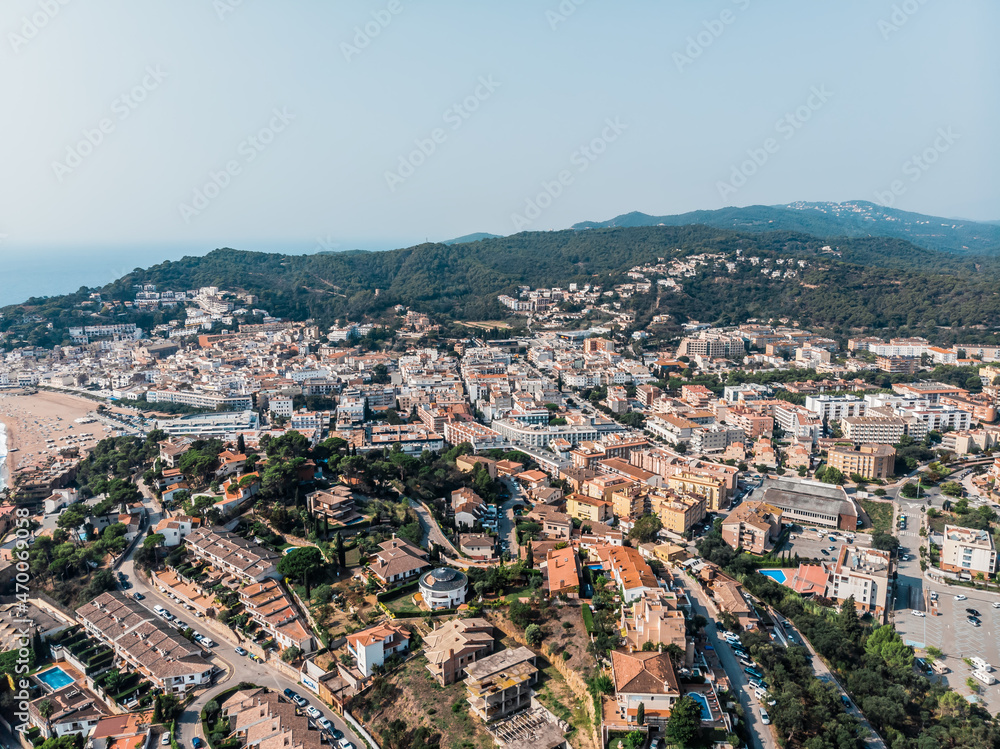 Drone view of the fortress with scenic sea views in Tossa de Mar. Drone shot of a municipality in Spain. People are relaxing on a sandy beach in Spain. Spa town near the Mediterranean Sea