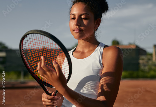 Black woman with tennis racket on court