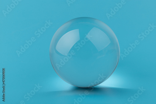 Crystal glass ball sphere transparent on blue background.