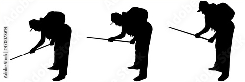 The woman bent down and works with a stick, defending herself with a stick. Black female silhouette on a white background in a cap with a bag on her back. The hand with the stick is down. Side view.