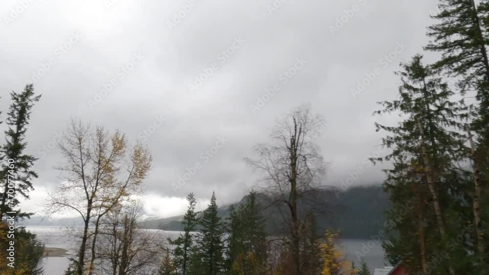 Slow Motion tracking shot of lake with misty Mountains in the distance - British Columbia Slow Motion tracking shot of lake with misty Mountains in the distance - British Columbia