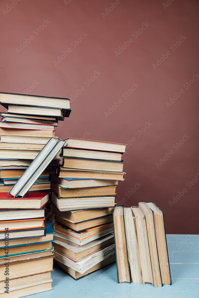 stacks of educational books in the library on a brown background stacks of educational books in the library on a brown background