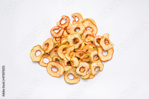 dried apples are poured into rings from a bag on a wooden table. Close up