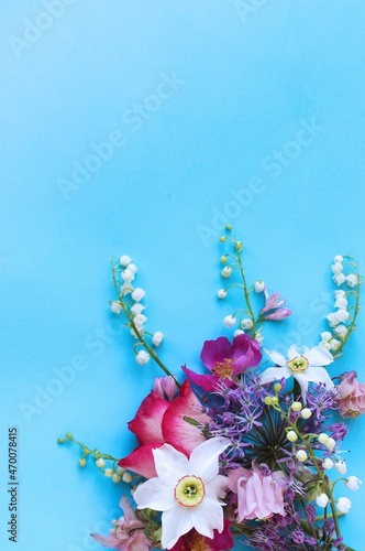 Daffodils, roses and lilies of the valley on a blue background. Spring flower arrangement. Bright color. Background for cards, greetings, invitations. © Olirina