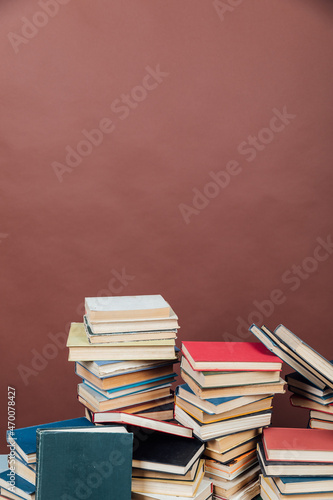 stacks of educational books in the library on a brown background