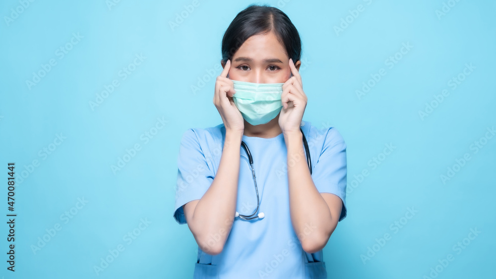 Asian Thai nurse or doctor wearing mask feeling worry isolated in studio on blue background