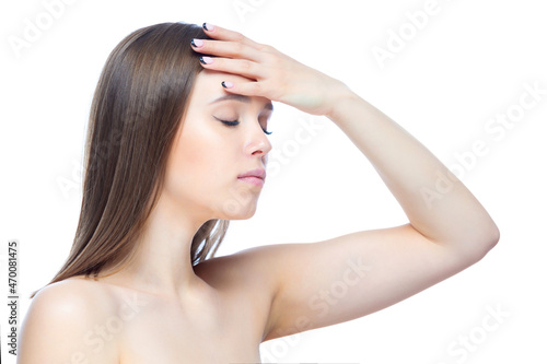 Photo of a young beautiful girl experiencing an attack of severe headache, standing with her hands near her head on a white background