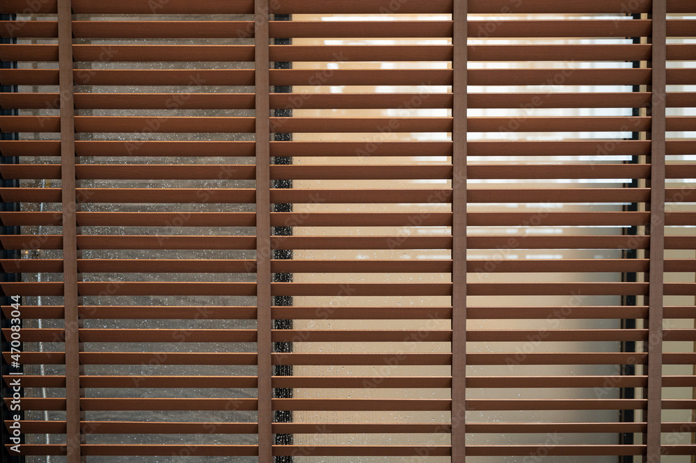 Pattern of brown wooden blinds on glass window Pattern of brown wooden blinds on glass window