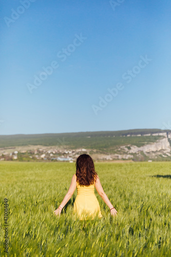 beautiful brunette woman in a field of green wheat
