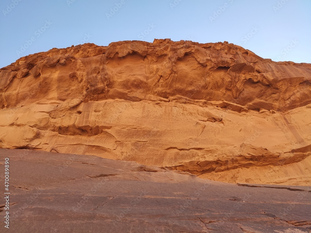 Dans la zone protégée du désert de Wadi Rum en Jordanie, avec de hautes montagnes rocheuses, exploration dans l'inconnu, sous un soleil et forte chaleur, escalade ou sport extrême vers le sommet