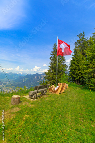 Woman relaxing in Brambruesch of Switzerland. Swiss cable car of Chur town with Swiss flag. Chur skyline in Grisons canton. Red cable car cabin from Chur to Kanzeli and Brambruesch. vertical view photo