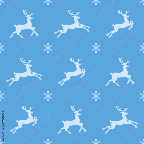 Christmas seamless pattern. White colored reindeer silhouettes on blue background with white snowflakes. Christmas texture