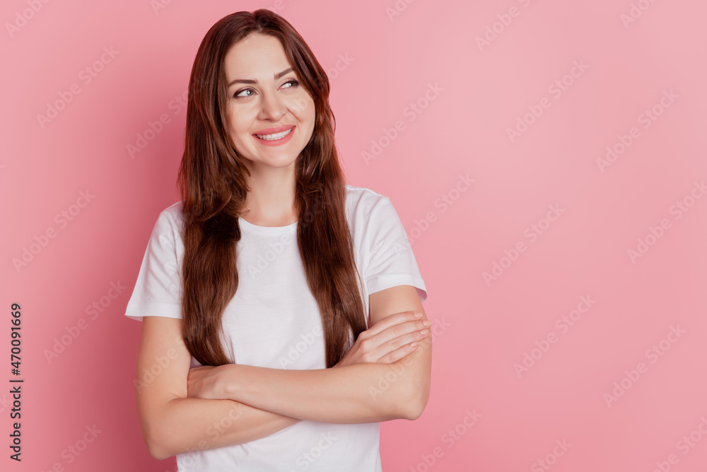 Portrait of interested inspired girl folded arms look empty space toothy smile on pink background Portrait of interested inspired girl folded arms look empty space toothy smile on pink background