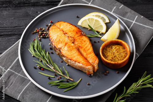 Fotografi baked salmon steak on a plate, top view