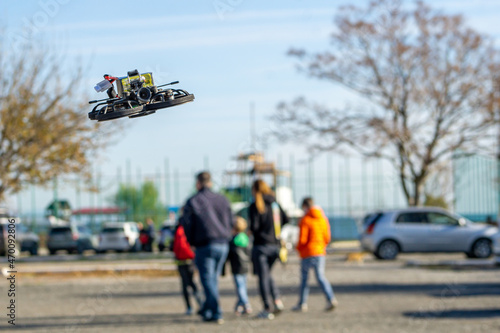 Mini drone flying in the park near people