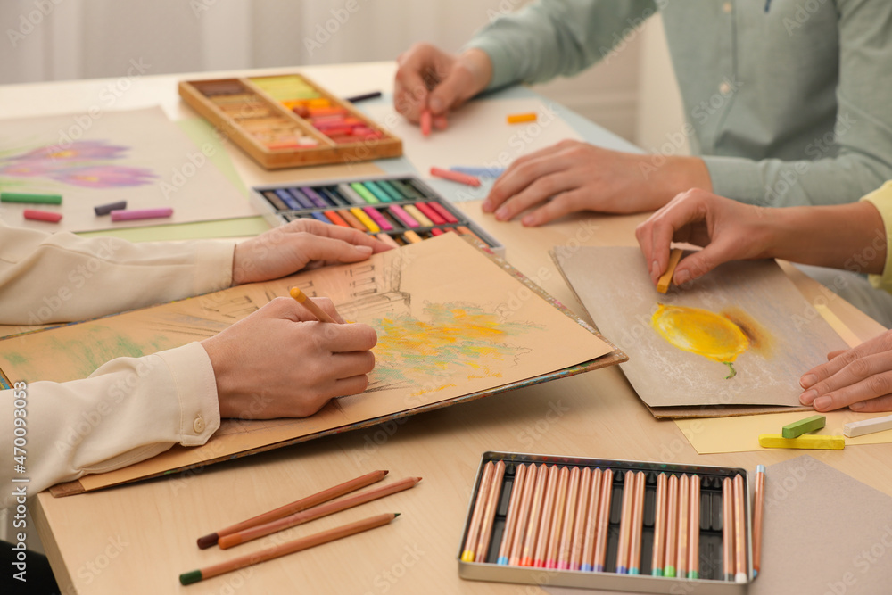 Artists drawing with soft pastels and pencils at table, closeup Artists drawing with soft pastels and pencils at table, closeup