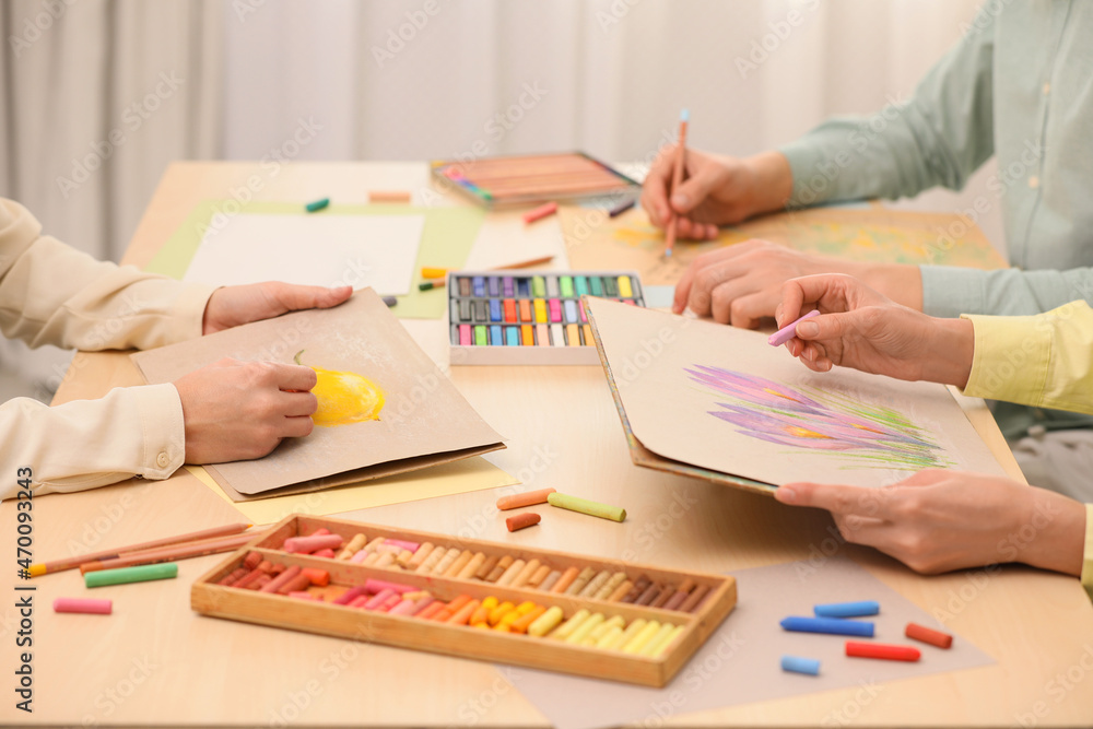 Artists drawing with soft pastels and pencils at table, closeup Artists drawing with soft pastels and pencils at table, closeup