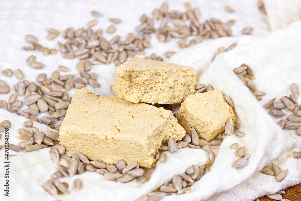 Traditional sweet turkish delight halva pieces with sunflower seeds on light background.