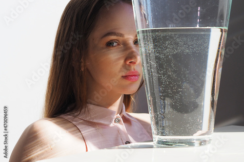 Conceptual surreal portrait Caucasian woman looking through a vase of water