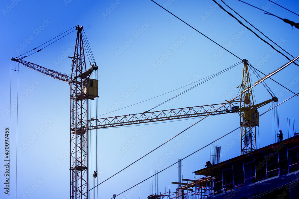Tower cranes are working on the construction of a multi-storey building Tower cranes are working on the construction of a multi-storey building