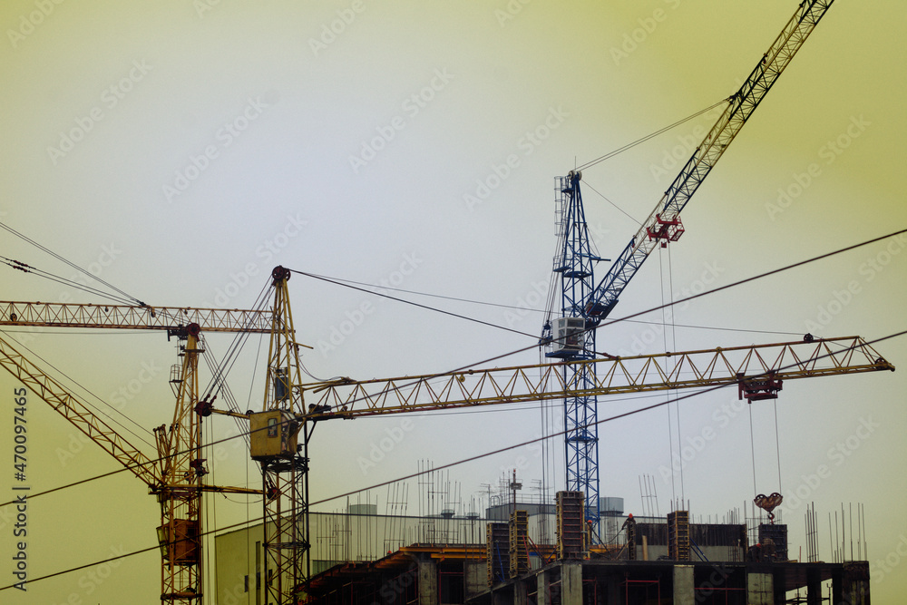 Tower cranes are working on the construction of a multi-storey building
