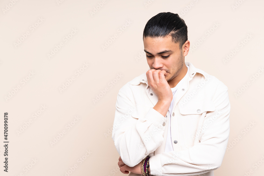 Asian handsome man over isolated background having doubts Asian handsome man over isolated background having doubts