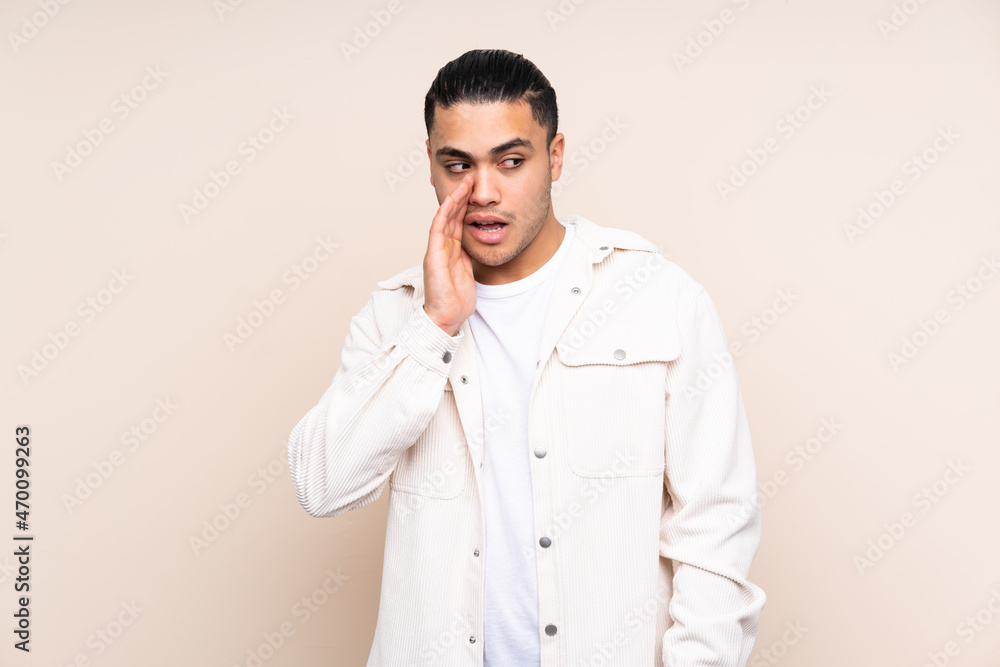 Asian handsome man over isolated background whispering something with surprise gesture while looking to the side Asian handsome man over isolated background whispering something with surprise gesture while looking to the side