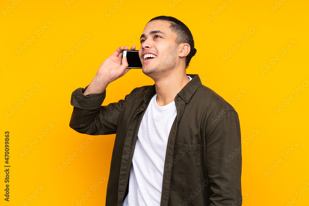 Naklejka premium Asian handsome man isolated on yellow background smiling and showing victory sign