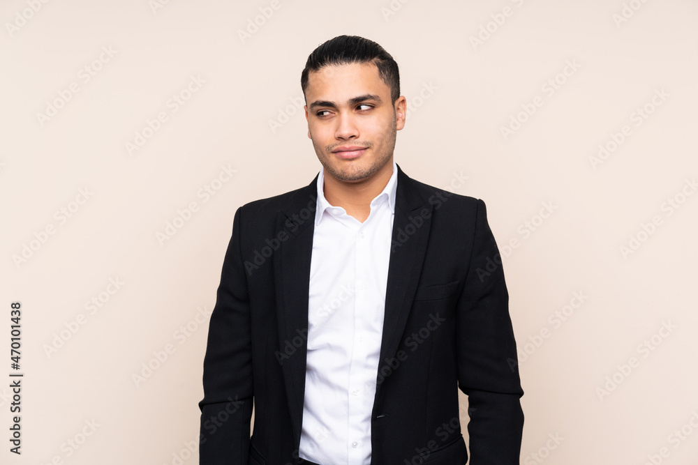 Asian business man isolated on beige background standing and looking to the side Asian business man isolated on beige background standing and looking to the side