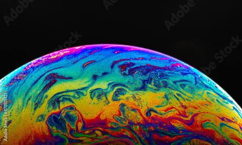 Virtual reality space with abstract multicolor psychedelic planet. Closeup Soap bubble like an alien planet on black background.