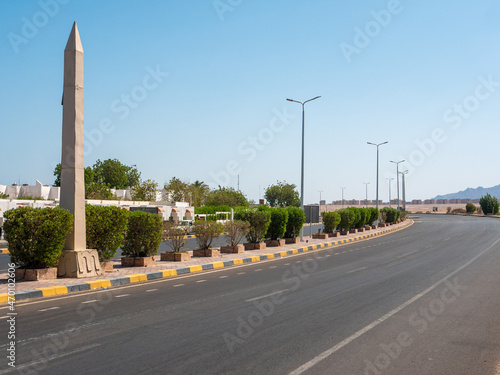 Safaga, Egypt - September 27, 2021: View of the main road leading into the distance. Lanterns and green bushes are installed along the road.