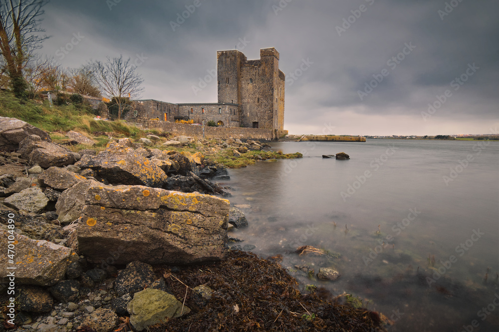 Dramatic cloudy scene of Oranmore Castle on rocky shore of Wild atlantic way in county Galway, Ireland 