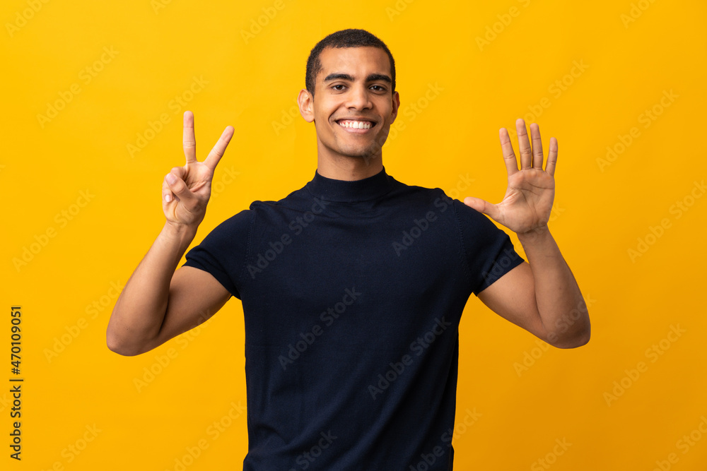 African American man counting numbres over isolated yellow background African American man counting numbres over isolated yellow background