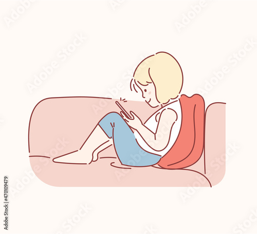 Little girl lying on the sofa with mobile phone in the living room at home. The concept of kids and gadget. Vector illustration in cartoon style