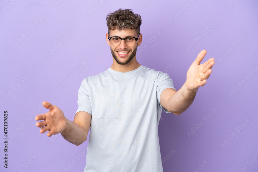 Delivery caucasian man isolated on purple background presenting and inviting to come with hand Delivery caucasian man isolated on purple background presenting and inviting to come with hand