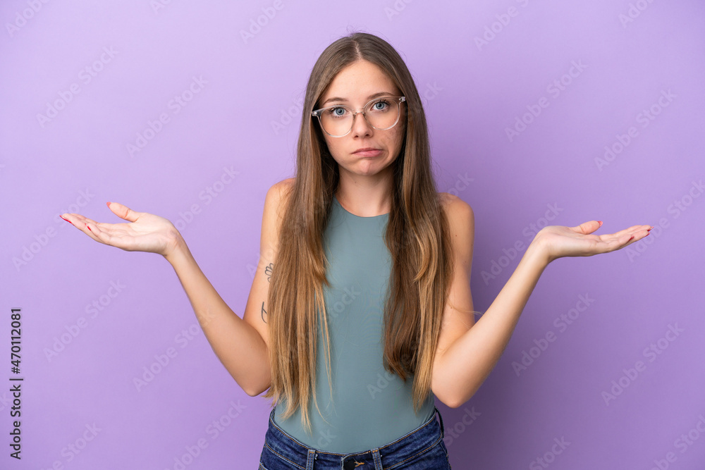Young Lithuanian woman isolated on purple background having doubts while raising hands Young Lithuanian woman isolated on purple background having doubts while raising hands