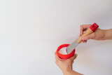 Woman holding putty wall with a spatula on white background. Human hands with putty knife smearing white paste
