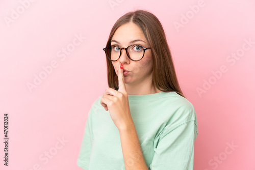 Young Lithuanian woman isolated on pink background With glasses and doing silence gesture