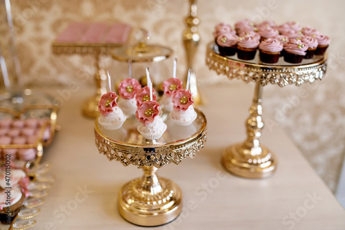 pink candies and cupcakes at a candy bar, decorated with pink caramel flowers and pastry beads