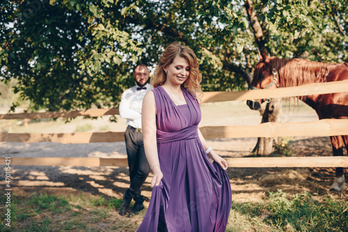 A loving couple on a date. Horseback riding. Purple dress.