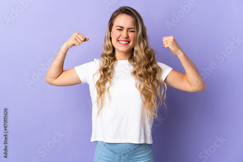 Young Brazilian woman isolated on purple background doing strong gesture