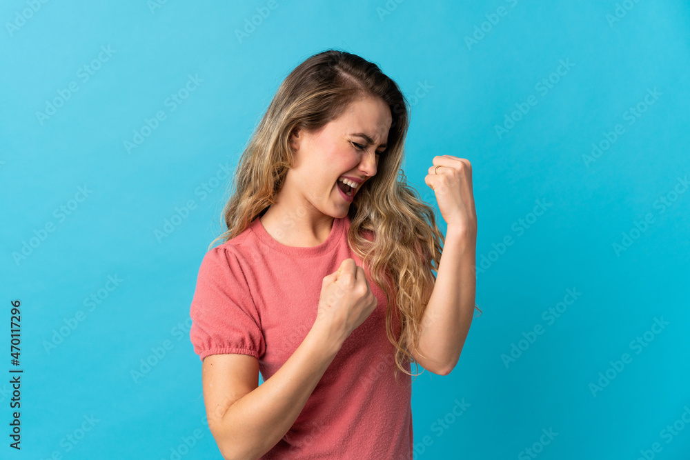 Fototapeta premium Young Brazilian woman isolated on blue background celebrating a victory