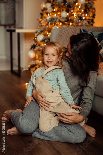 Happy family mother and daughter at home near Christmas tree waiting for New Year © Daria