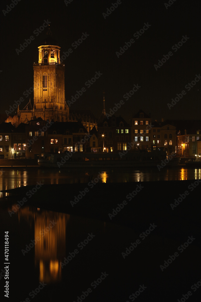 The Great Church and buildings in the City of Deventer, the Netherlands, at night with reflection in the water

