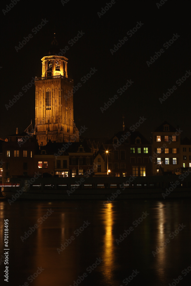 The Great Church and buildings in the City of Deventer, the Netherlands, at night with reflection in the water