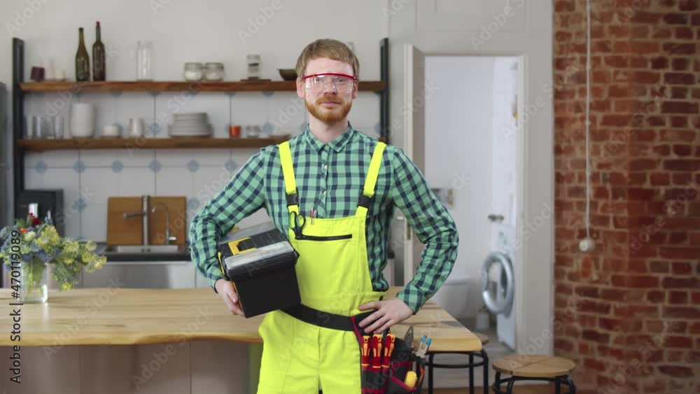 Repairman hold tool box in kitchen and look at camera. Real time Repairman hold tool box in kitchen and look at camera. Real time