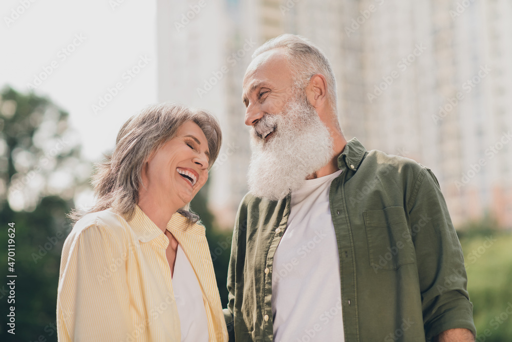Photo of funky expression aged grey hair couple laugh together wear shirts outdoors day off in park Photo of funky expression aged grey hair couple laugh together wear shirts outdoors day off in park